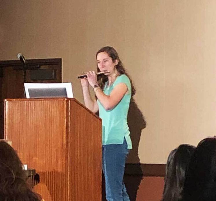 Photo of Annie Tobiasiewicz playing the piccolo during the Soliant Talent Show