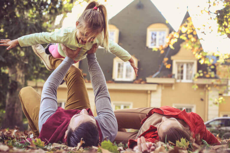 Family playing on lawn in front of their home