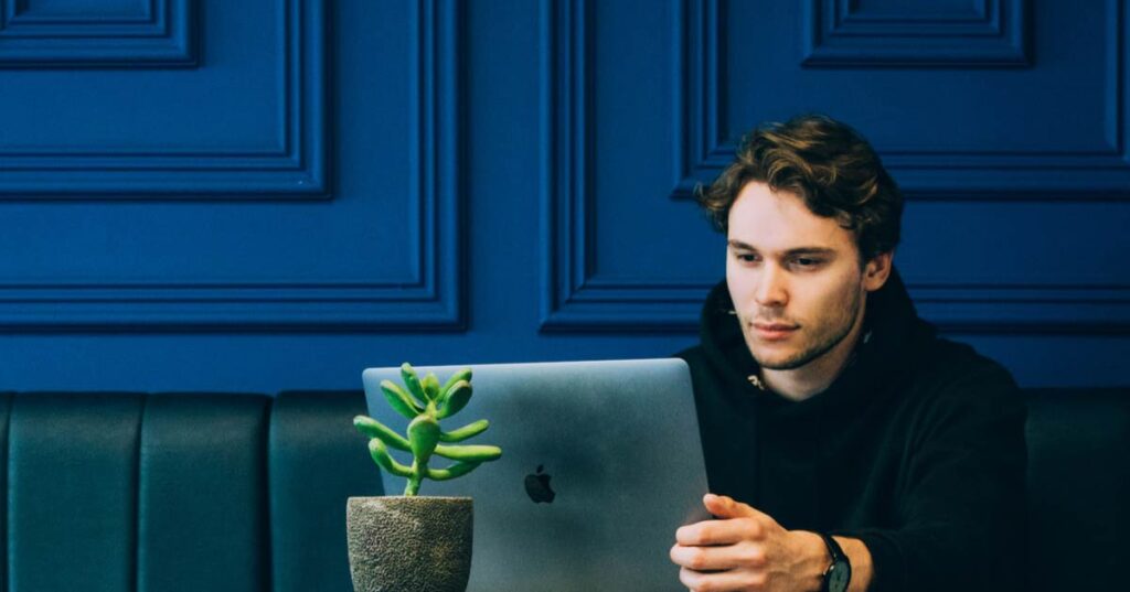 Developer sitting with looking at his laptop